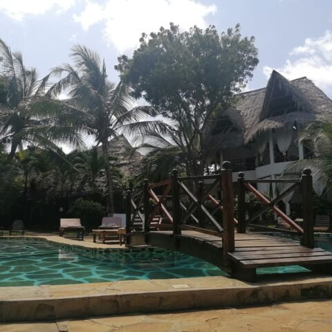 Thatched villa beside a garden pool
